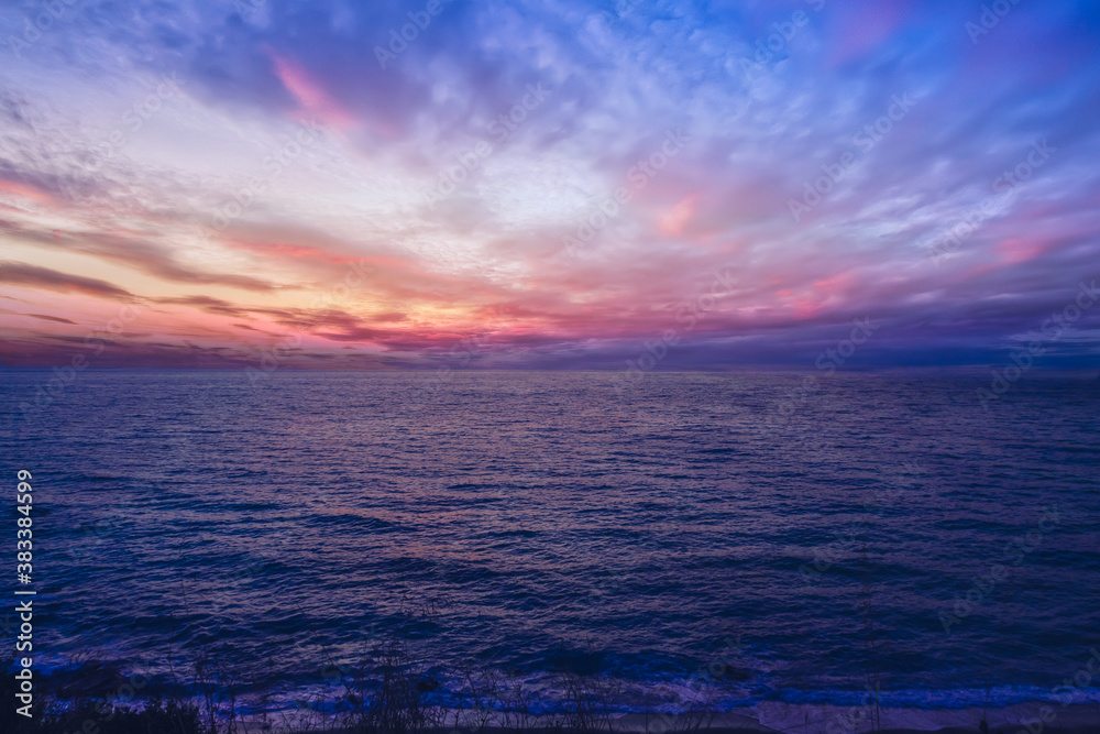 Obraz premium Beautiful pink sunset with sun rays over sea. 