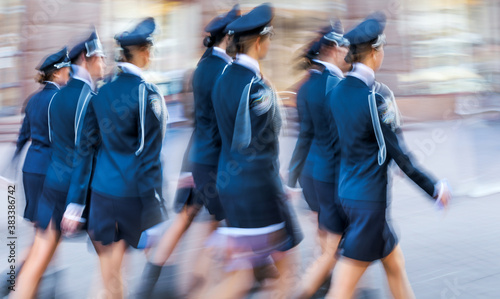 a group of girls in uniform strides across the city