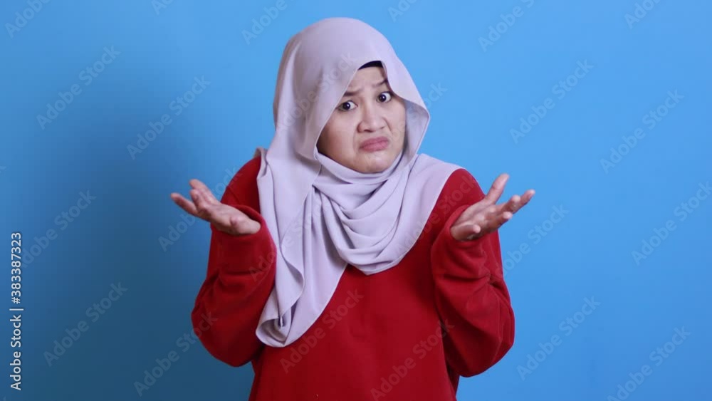 Portrait of Asian muslim woman wearing hijab shows refusal or denial gesture, shoulder shrug, I don't know expression Portrait of Asian muslim woman wearing hijab shows refusal or denial gesture, shoulder shrug, I don't know expression