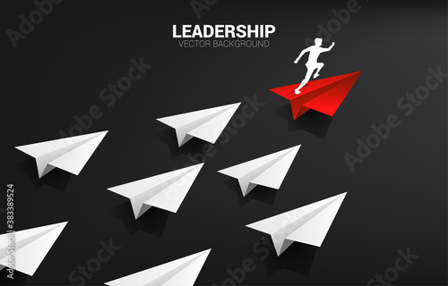 Silhouette of businessman running on red origami paper airplane leading group of white. Business Concept of leadership and vision mission.