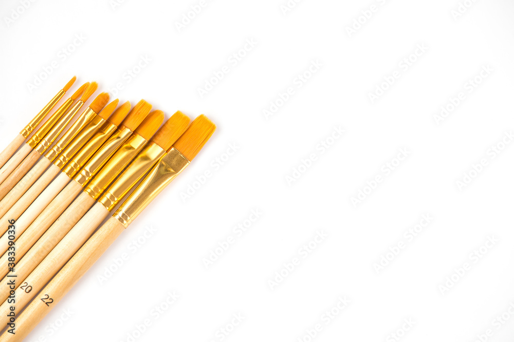 New brushes of different sizes on a wooden handle isolated on white background. New brushes of different sizes on a wooden handle isolated on white background.
