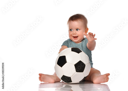 Baby boy sitting and playing a classic soccer ball on a white background.