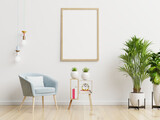 Poster mockup with vertical frames on empty white wall in living room interior with blue velvet armchair.