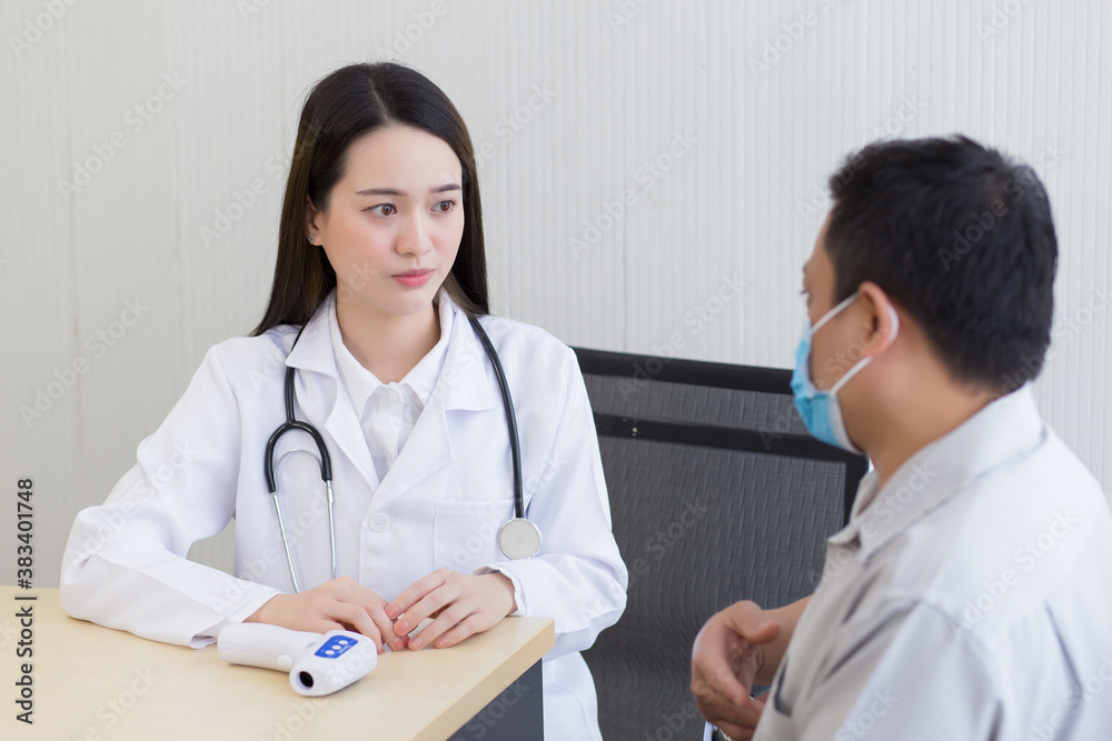 An Asian man patient talking about his pain and symptom with a woman doctor at hospital. Doctor listen and give advice to hims. An Asian man patient talking about his pain and symptom with a woman doctor at hospital. Doctor listen and give advice to hims.