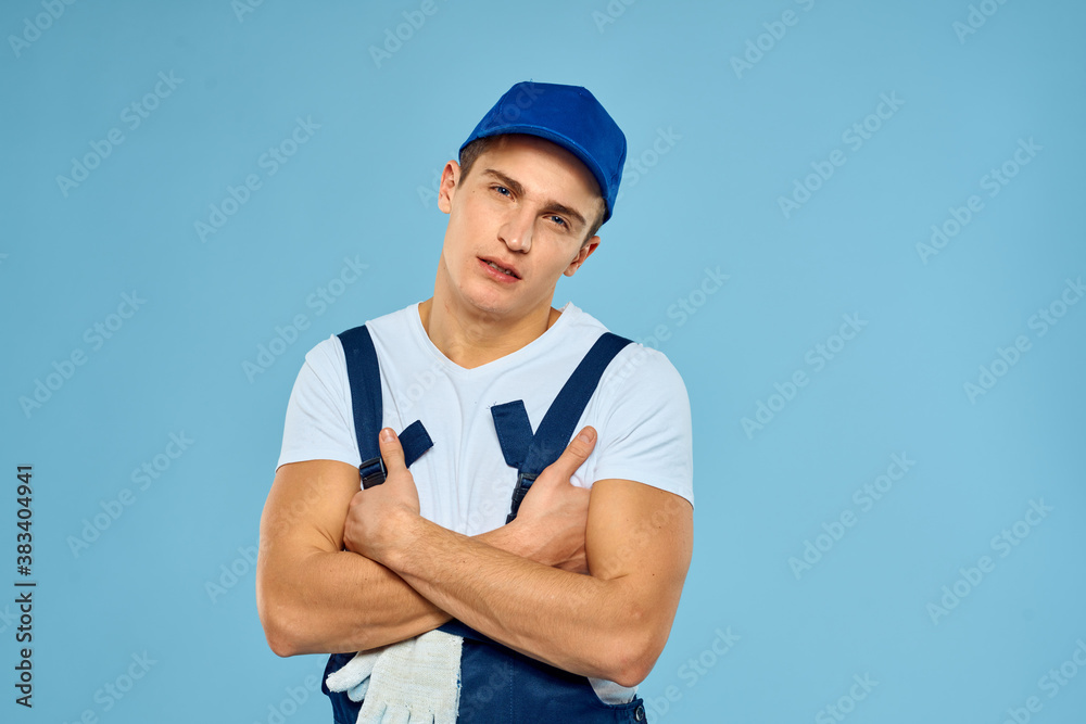 Working man in uniform of gloves loader rendering service blue background Working man in uniform of gloves loader rendering service blue background
