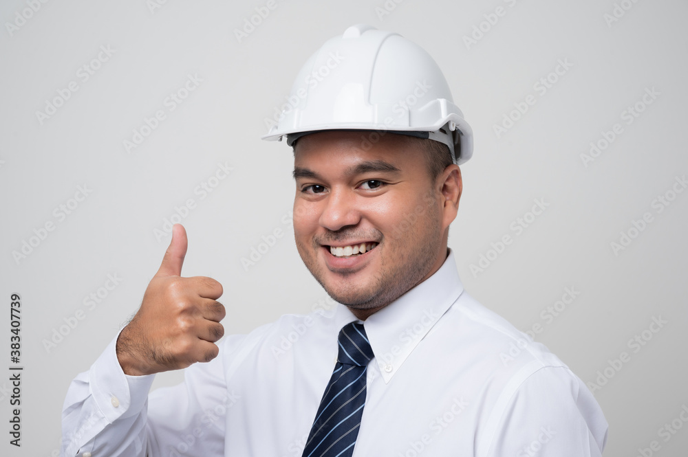 Smiling young asian civil engineer helmet hard hat standing showing thumbs up on isolated white background. Mechanic service concept. Smiling young asian civil engineer helmet hard hat standing showing thumbs up on isolated white background. Mechanic service concept.