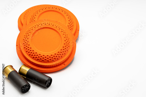 Clay disc flying targets and shotgun bullets on white background ,Clay Pigeon target