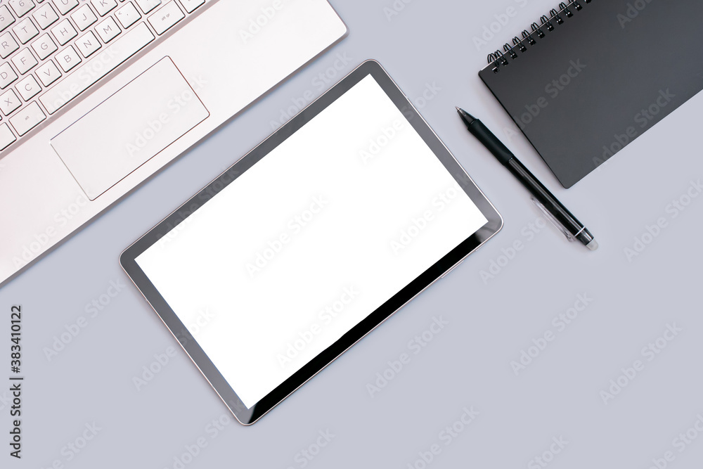 vertical photo of a female office work environment with a laptop, tablet and black Notepad on a gray background. the view from the top