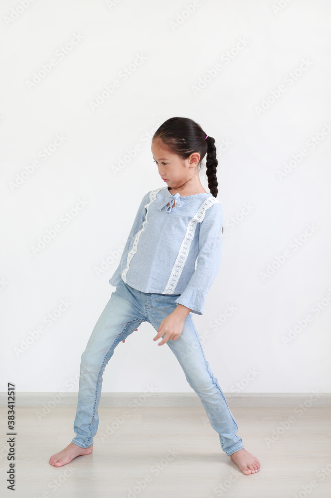 Portrait of asian little girl standing posture in room against white wall background. Portrait of asian little girl standing posture in room against white wall background.