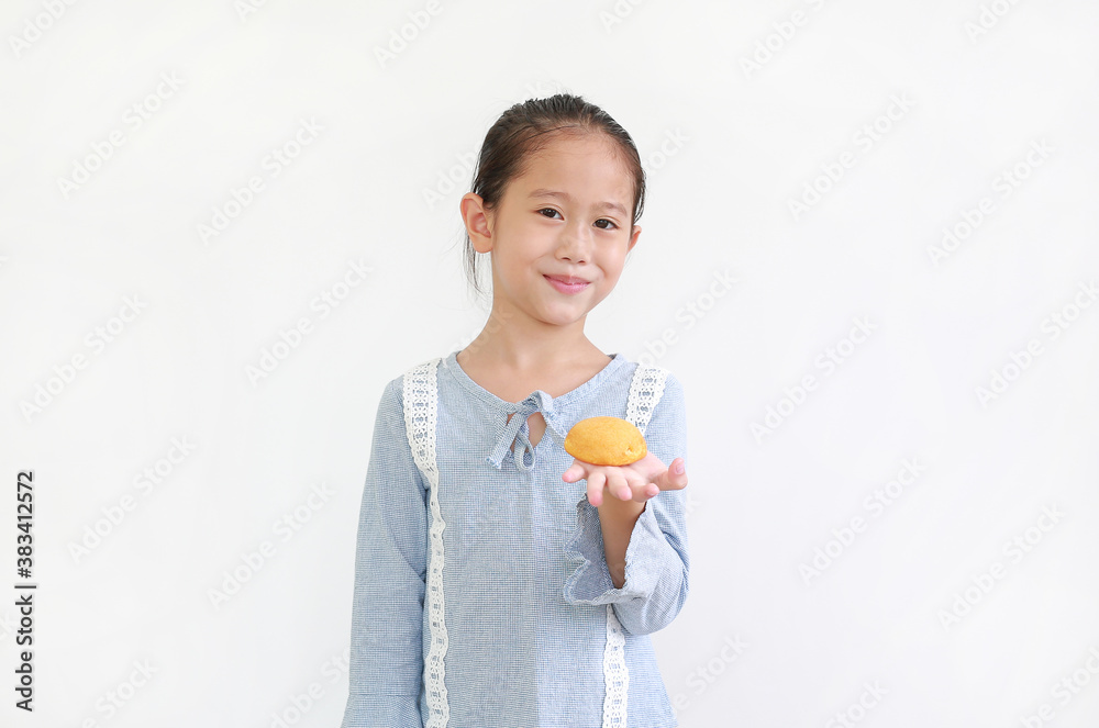 Happy asian little kid girl hold and eating Custard Cake isolated over white background. Happy asian little kid girl hold and eating Custard Cake isolated over white background.