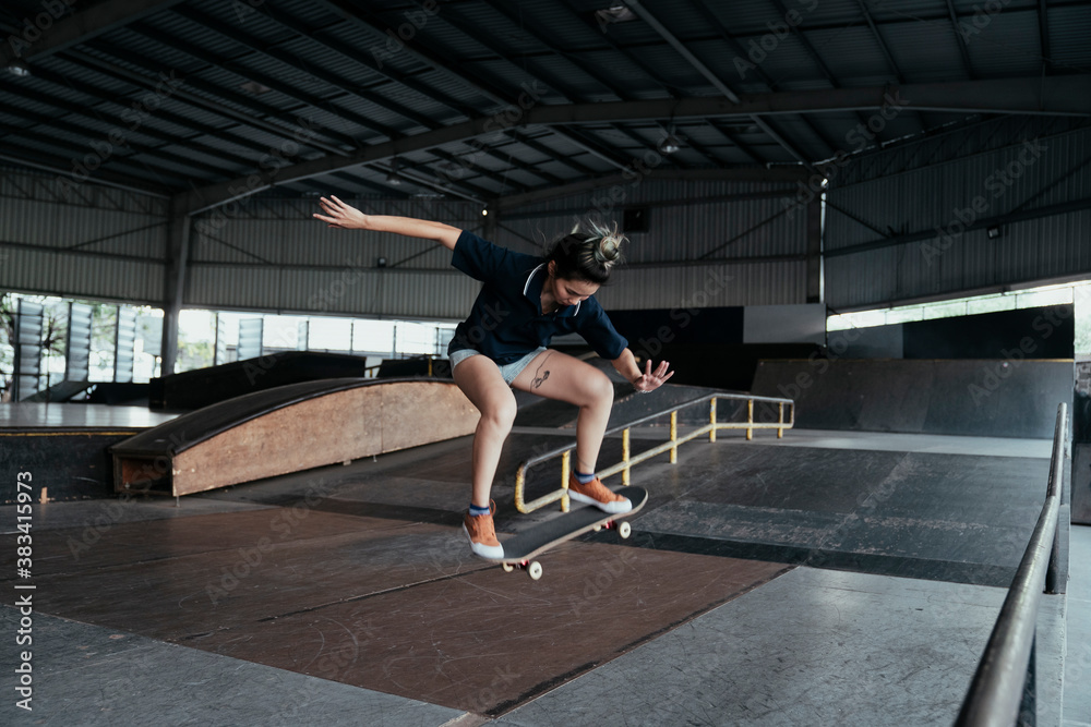 Skateboard player woman doing jump flip.