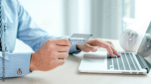 Businessman hand holding credit card to online shopping from home with laptop  payment e-commerce  internet banking  spending money for next holidays