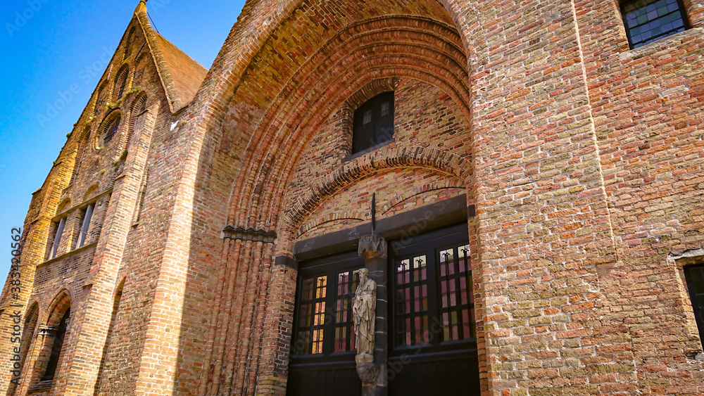 Obraz premium A Look At The Walls, Entrance And Roof Of An Ancient Brick Christian Church In Bruges, Belgium