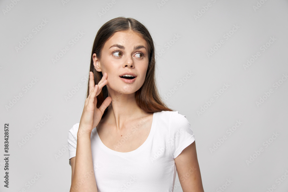 A woman with a surprised expression looks towards a white T-shirt A woman with a surprised expression looks towards a white T-shirt