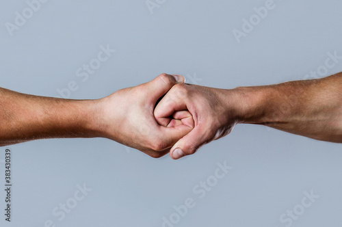 Male hand united in handshake. Man help hands, guardianship, protection. Two hands, isolated arm, helping hand of a friend. Friendly handshake, friends greeting photo