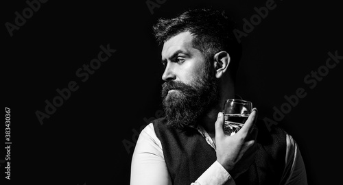 Bearded drink cognac. Man holding a glass of whisky. Sipping whiskey. Man with beard holds glass brandy. Macho drinking. Black and white