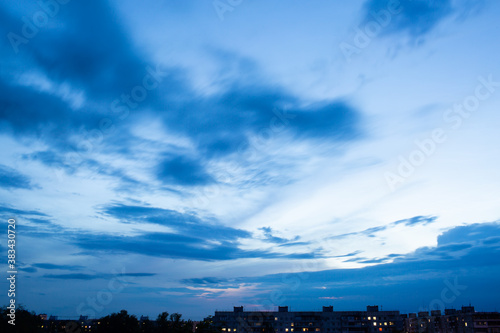 Wall Mural In the dark blue sky, only silhouettes of houses are visible