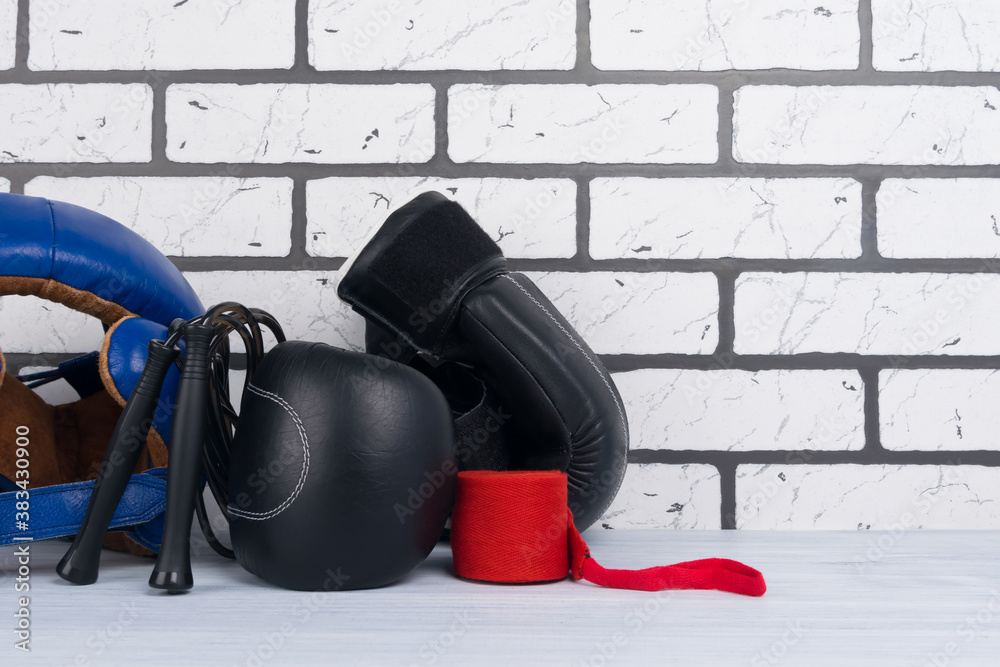 blue helmet, jump ropes, protective bandages and gloves for boxing, against a light brick wall, there is a place for inscription