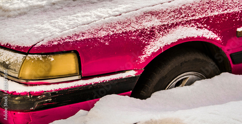 Car closeup. Fragment. Old car under the snow. Abandoned. Winter snow. Pink photo