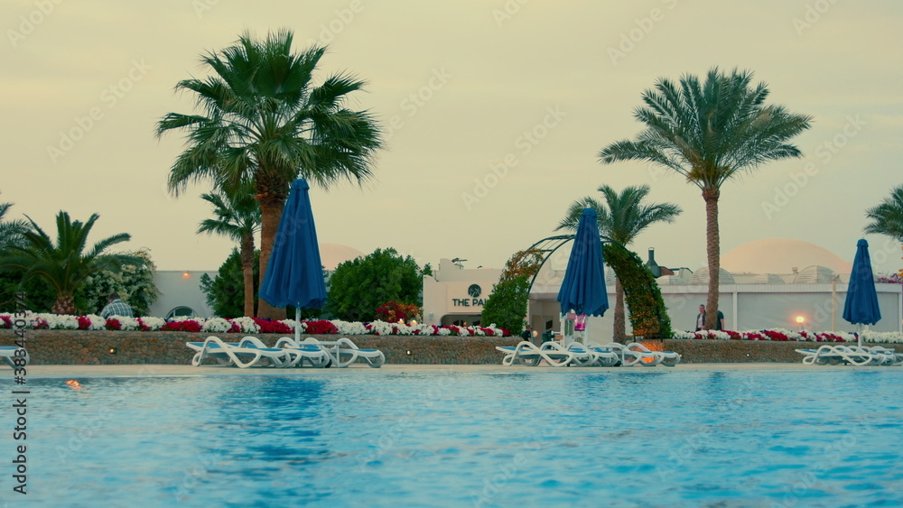 Fototapeta premium Beautiful swimming pool at hurghada resort in summer evening. Open air lido.
