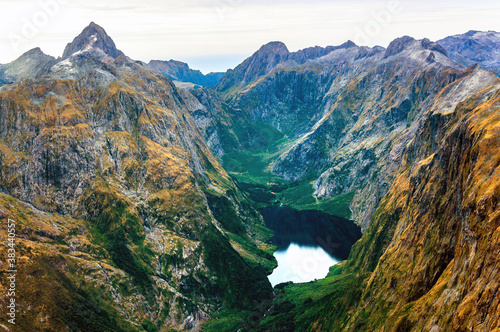 Фотография Amazing aerial view of yellow color mountain range, lake in the valley, forest o