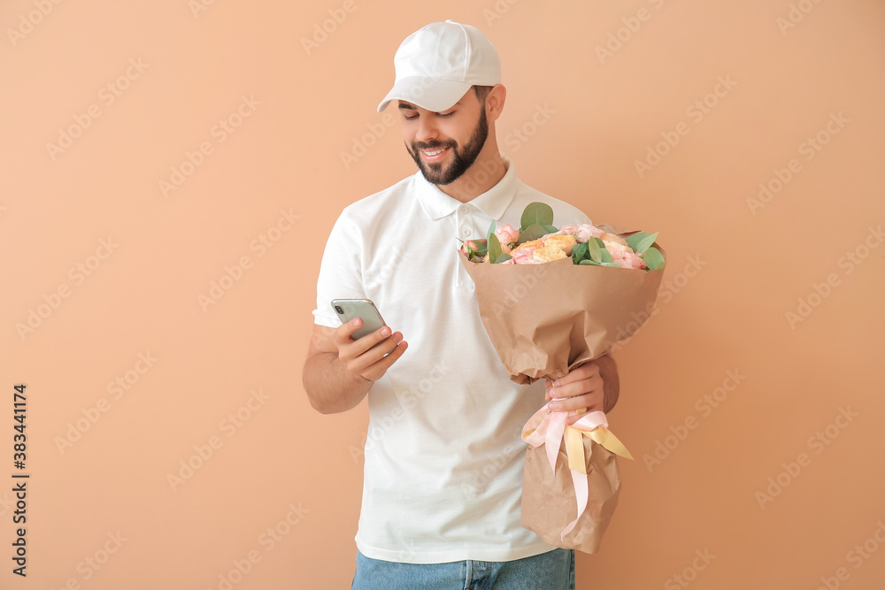 Delivery man with bouquet of flowers and mobile phone on color background Delivery man with bouquet of flowers and mobile phone on color background