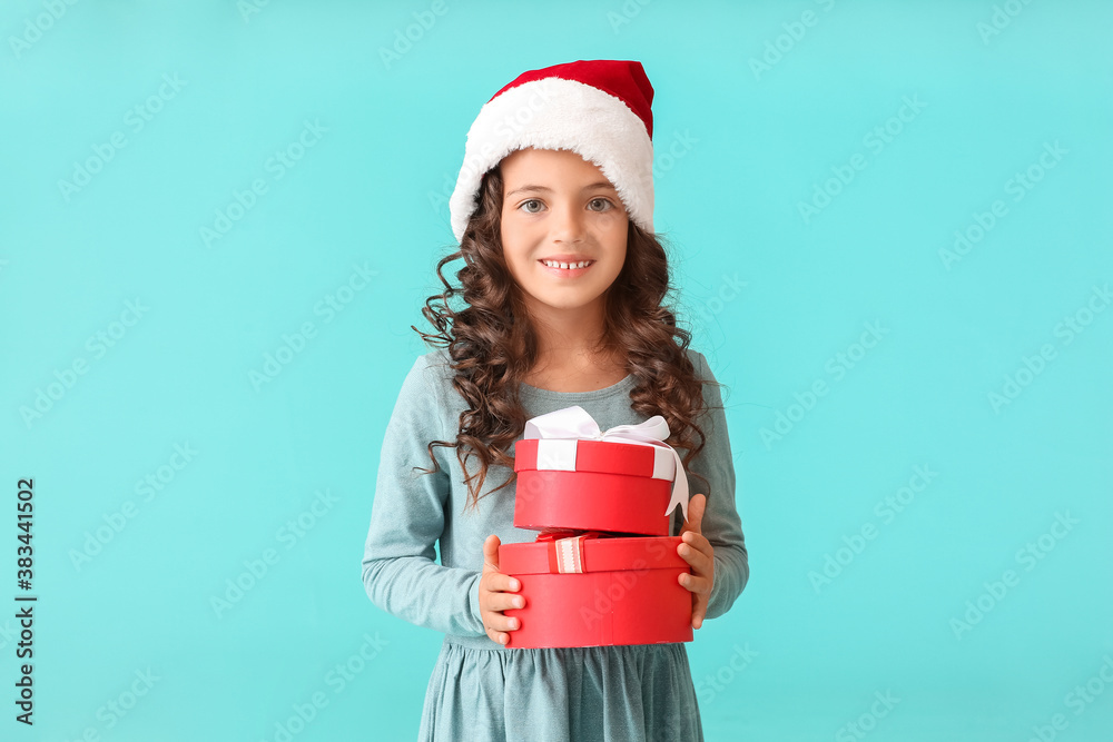 Cute little girl in Santa hat and with gift boxes on color background Cute little girl in Santa hat and with gift boxes on color background