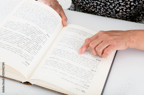 Фотография The elderly are carefully watching an opened book