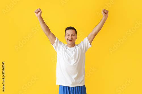 Sporty young man on color background. Concept of goal achievement