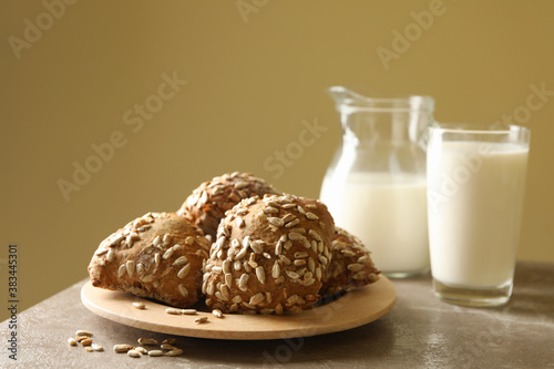 Fresh baked buns and milk on gray table