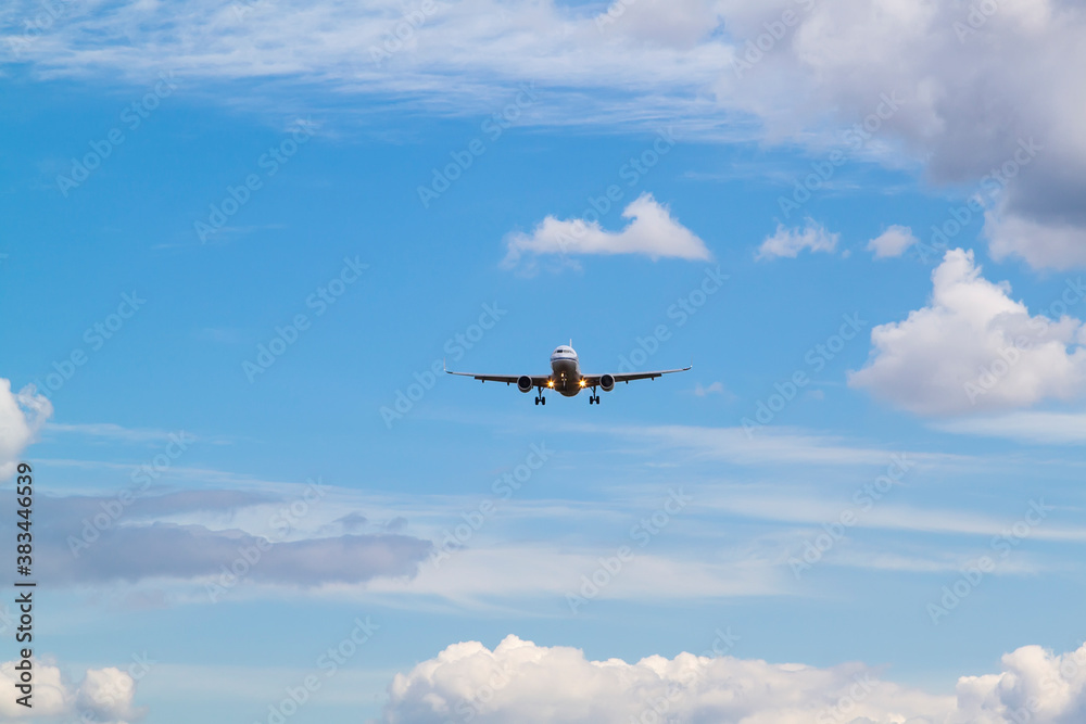 white passenger plane comes in to land with natural background of white clouds and blue sky white passenger plane comes in to land with natural background of white clouds and blue sky