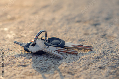 A lost keys on the ring on the ground illuminated with sun rays, selective focus