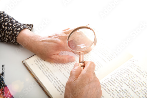 Canvastavla The elderly are reading books with a magnifying glass in hand