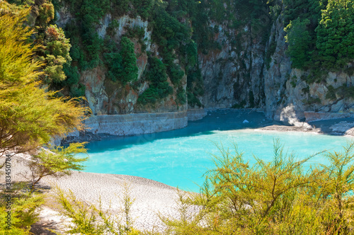 Amazing turquoise blue Inferno Crater Lake in Echo Crater in Waimangu volcanic valley in Rotorua, New Zealand landscape