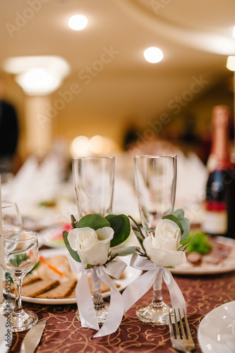 Two Wedding glasses are decorated flowers with ribbons. Close up.