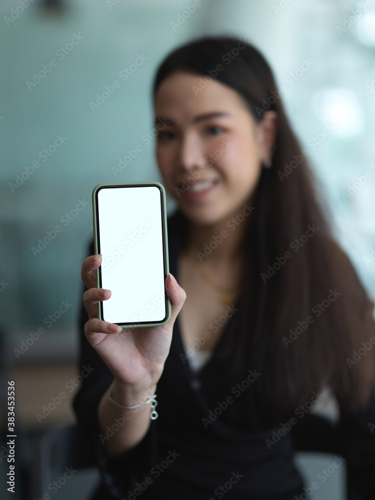 Businesswoman showing mock up smartphone screen in office room
