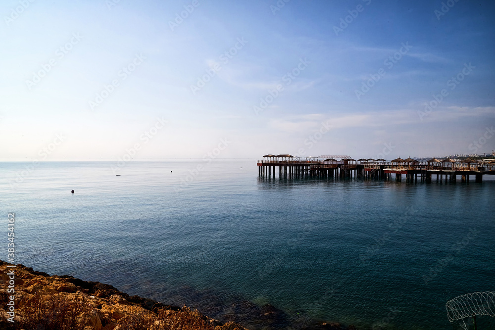 Rocky coast, sea, sky and pier in the background Rocky coast, sea, sky and pier in the background
