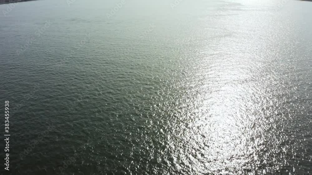 Drone flight over the sea surface with waves and sun reflection in the water. Drone flight over the sea surface with waves and sun reflection in the water.