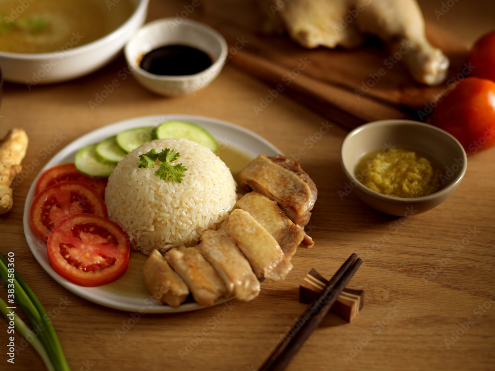 Hainanese chicken rice (steamed chicken rice) with sauces and veggies