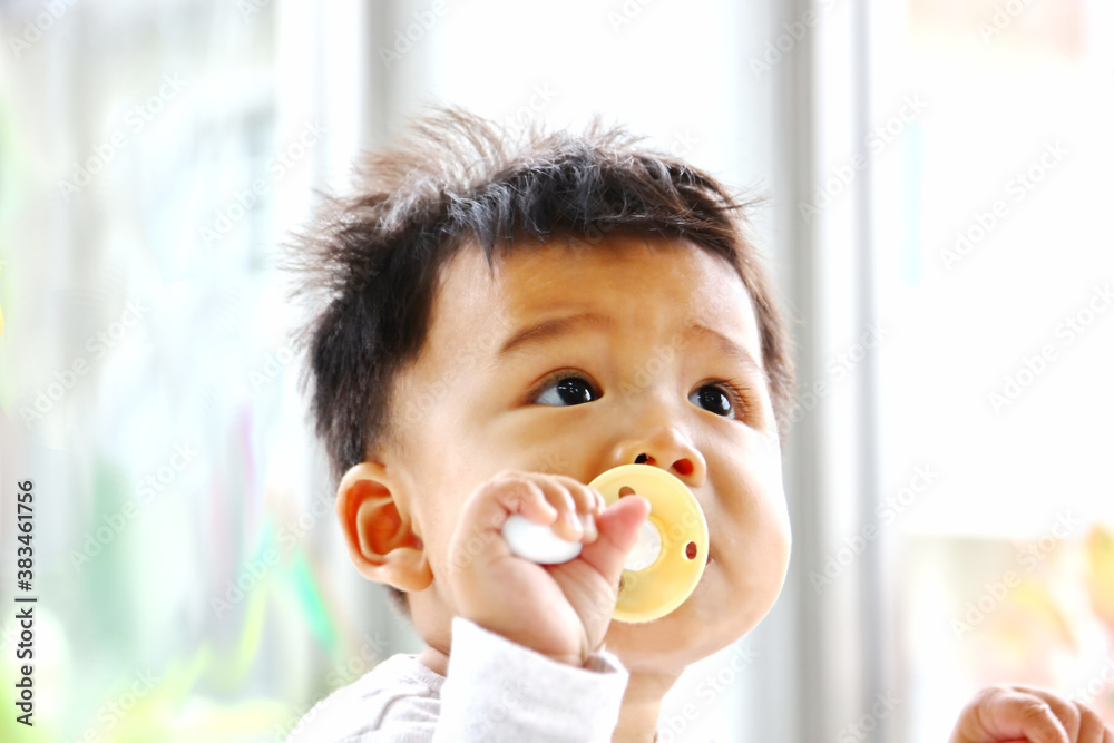 Asian baby happy with latex nipple and eyes looking on Asian baby happy with latex nipple and eyes looking on