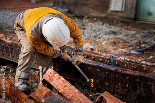 travailleur de chantier découpant de l'acier rouillé au chalumeau