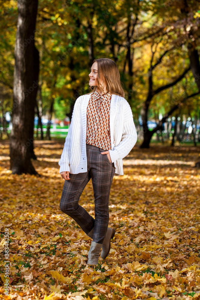 Blonde teenage girl posing in autumn park Blonde teenage girl posing in autumn park