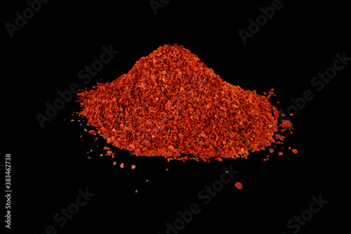 Heap of dried crushed hot red pepper on isolated black
