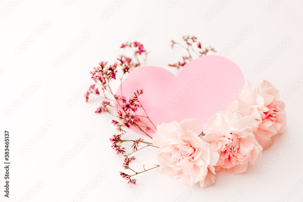Naklejka premium Three pink carnations isolated on white background with heart symbol of love