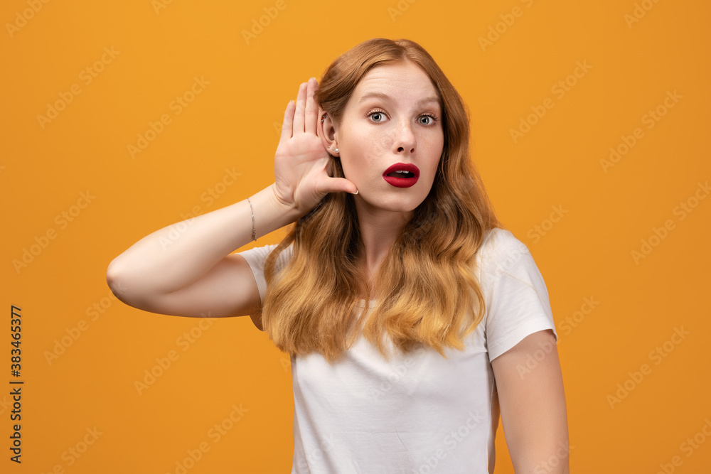 Young pretty woman with wavy redhead holding hand near ear Young pretty woman with wavy redhead holding hand near ear