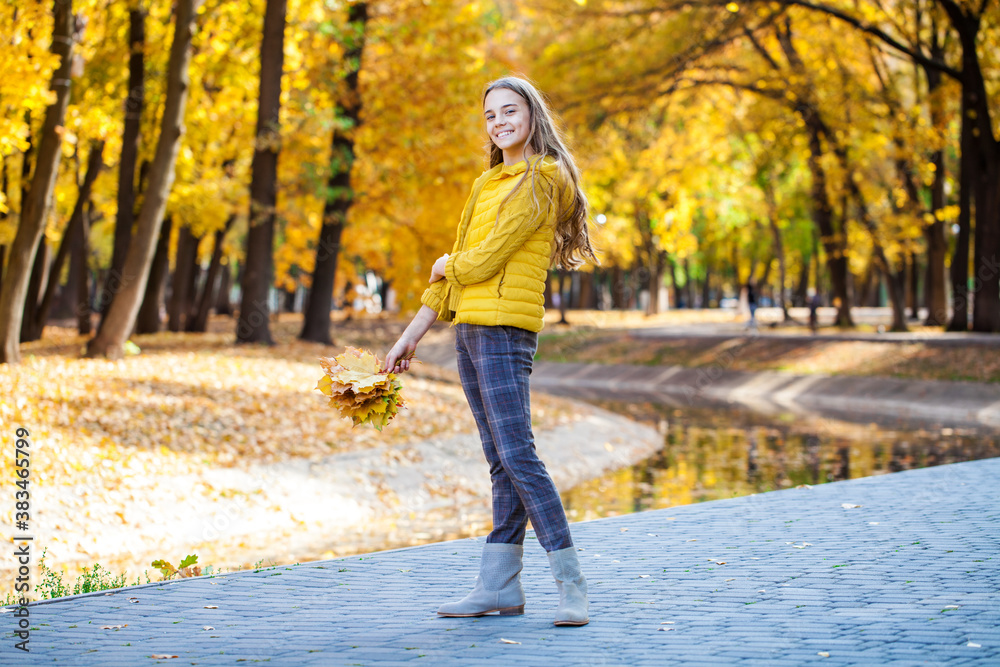 Obraz premium Blonde teenage girl posing in autumn park