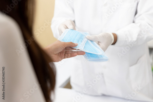 Woman buy protective hygienic mask with pharmacist in modern pharmacy. Close up hand