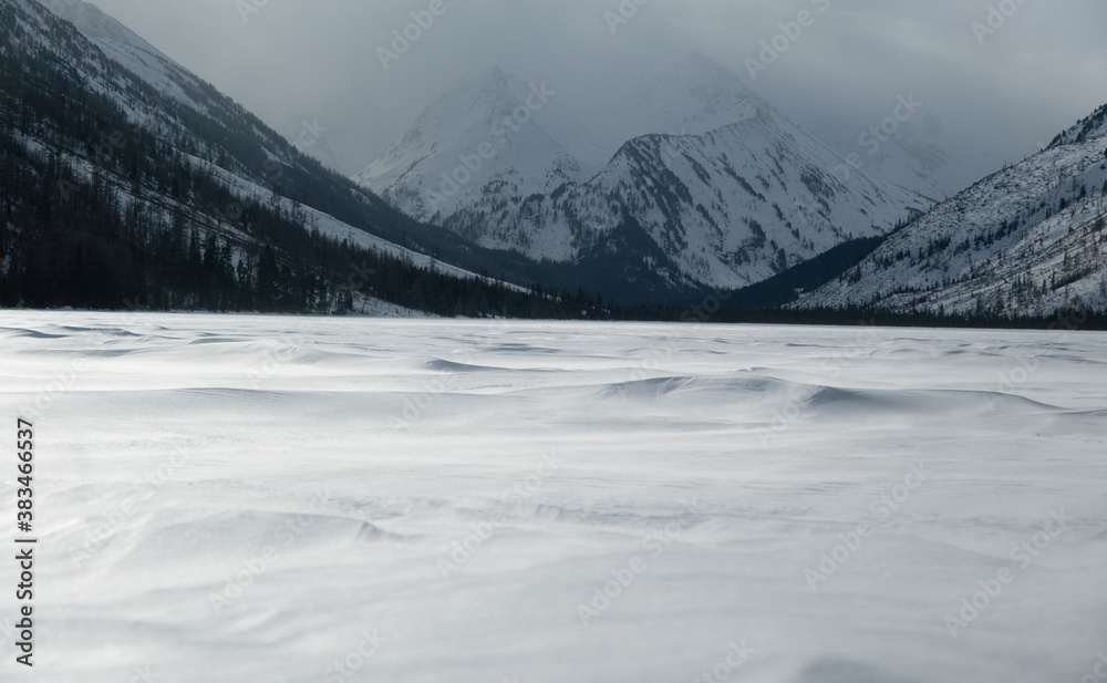 Obraz premium snow dunes against the background of winter mountains. Multinskie Lakes, Altai, Russia