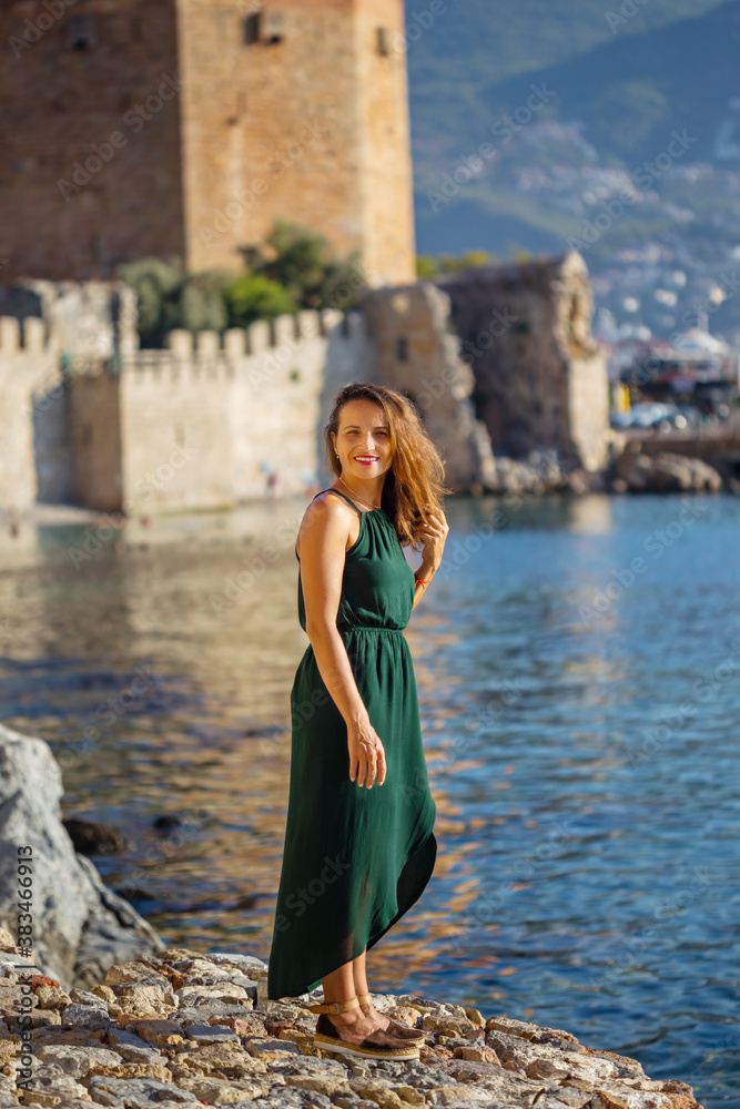 Travelling to Alanya. Smiling female posing by the sea in front