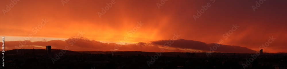 High resolution panorama of scenic sunset. Autumn red and orange sunset, end of the rain.